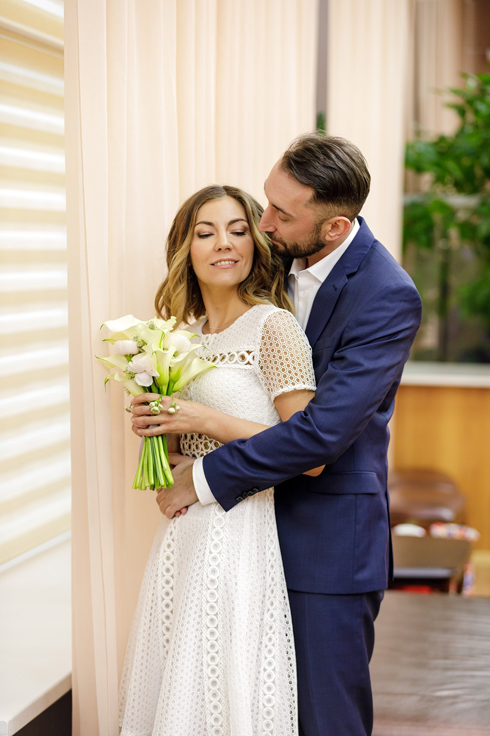 Жених с невестой обнимаются в загсе