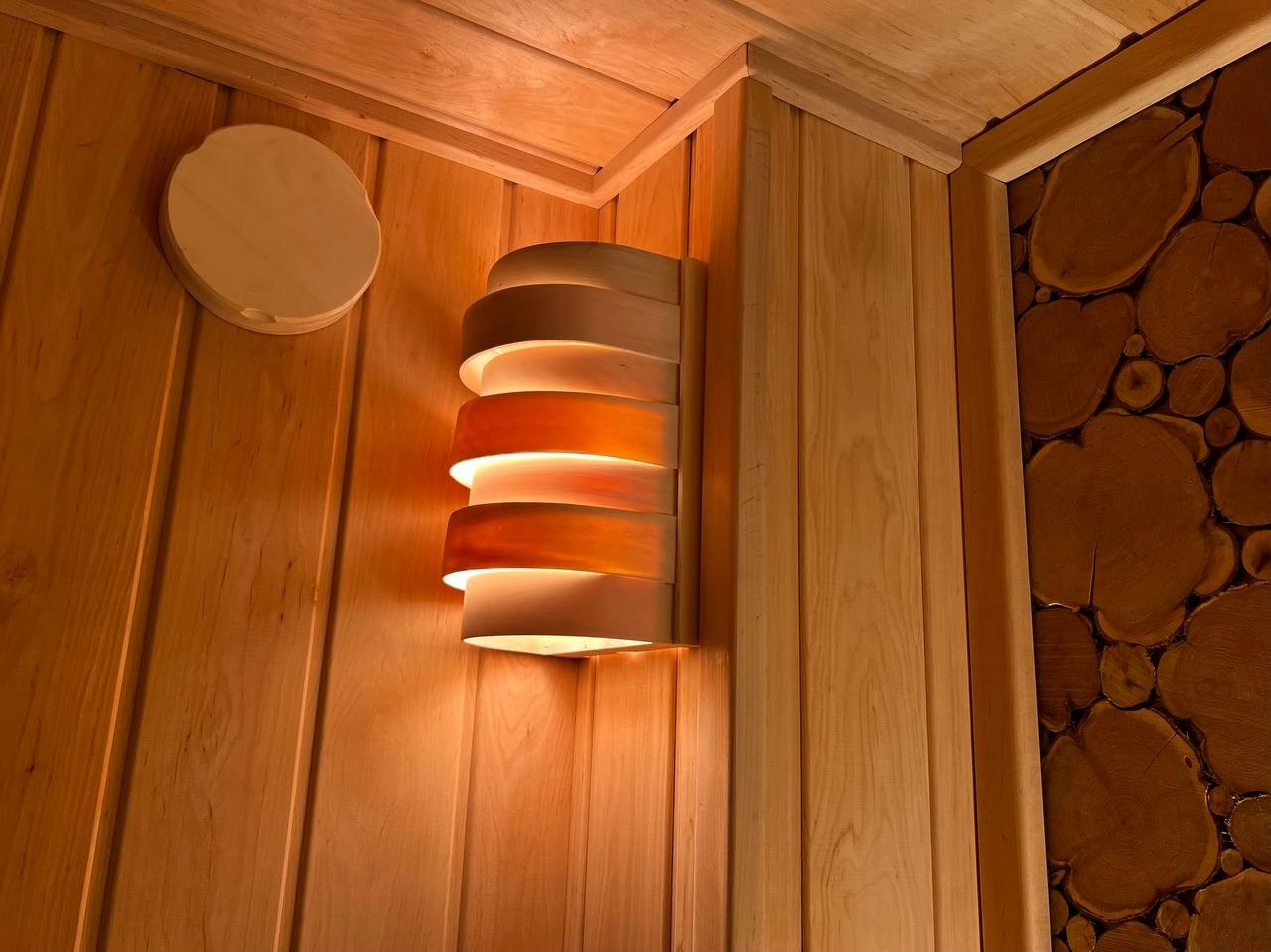 Уютная сауна на Петроградке из белорусской ольхи с можжевеловым панно, винтажными светильниками и паром от Harvia Cilindro. SaunaTopMasters