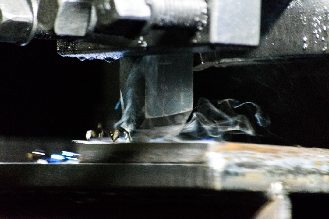 Производство, станок, резка металла в черно- белых тонах Промышленное фото