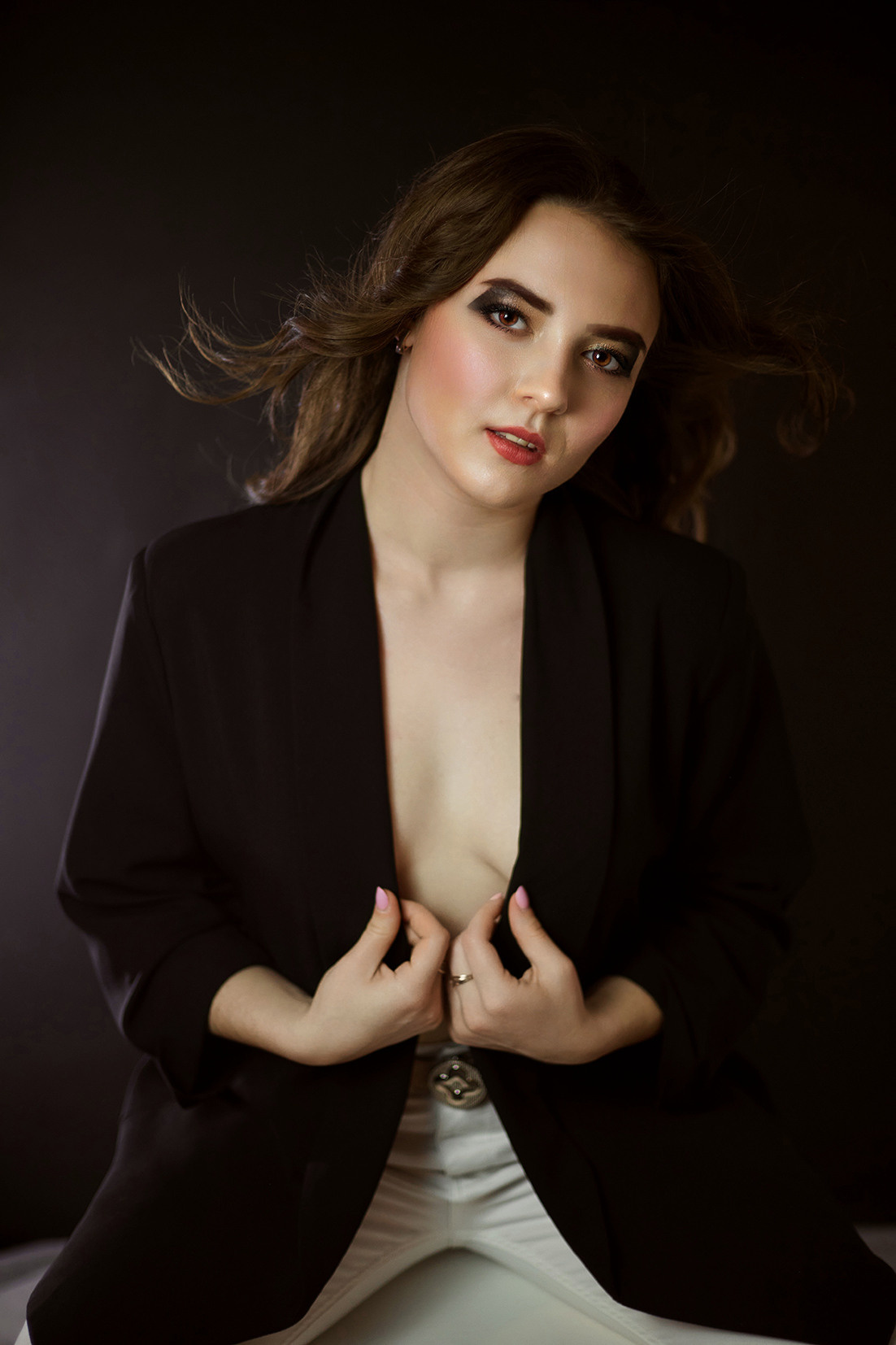 Студийный портрет девушки. Девушка с развивающимися волосами в черном пиджаке на голое тело на черном фоне. Фотограф. Тимашевск. Кубань. Краснодарский край.