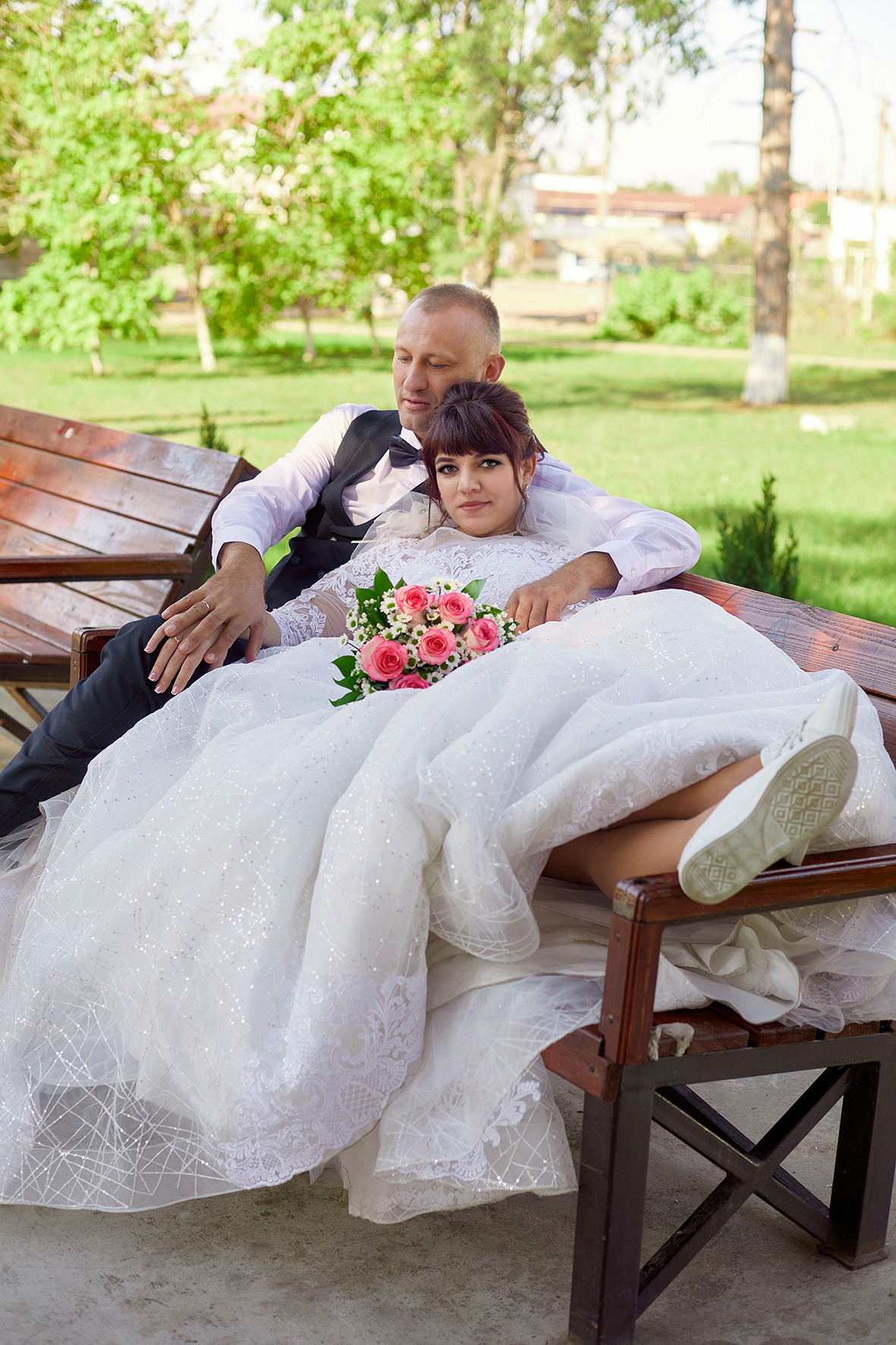 Невеста и жених сидят на скамье в парке. Фотограф. Тимашевск. Кубань. Краснодарский край.
