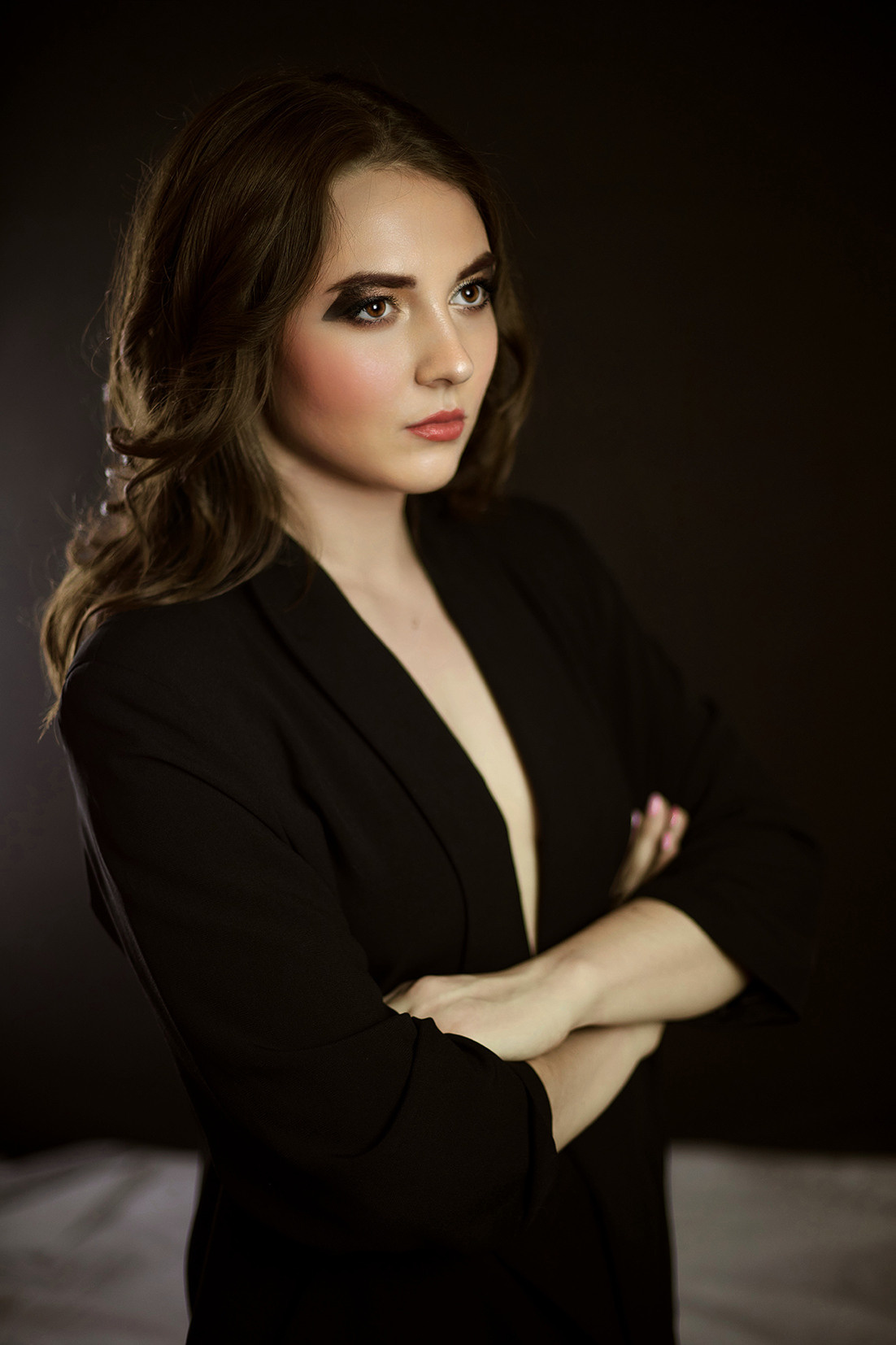 Студийный портрет девушки. Девушка с развивающимися волосами в черном пиджаке на голое тело на черном фоне. Фотограф. Тимашевск. Кубань. Краснодарский край.