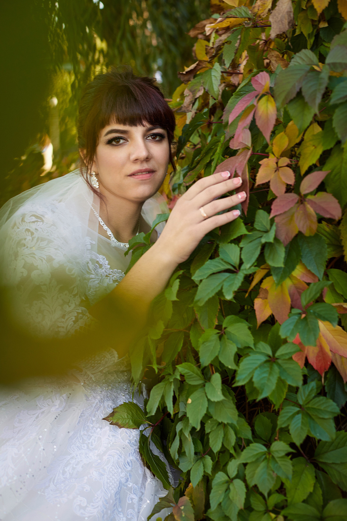 Невеста стоит в парке на фоне вьющегося плюща. Фотограф. Тимашевск. Кубань. Краснодарский край.