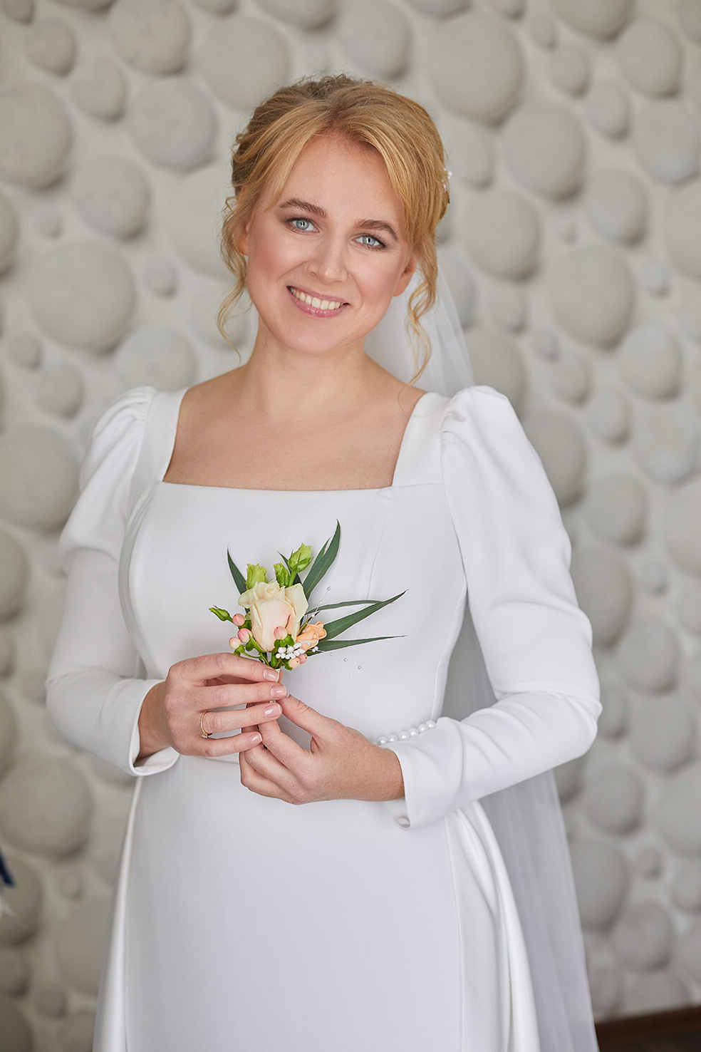Утро невесты. Невеста с бутоньеркой в руках. Невеста улыбается. Фотограф. Тимашевск. Кубань. Краснодарский край.