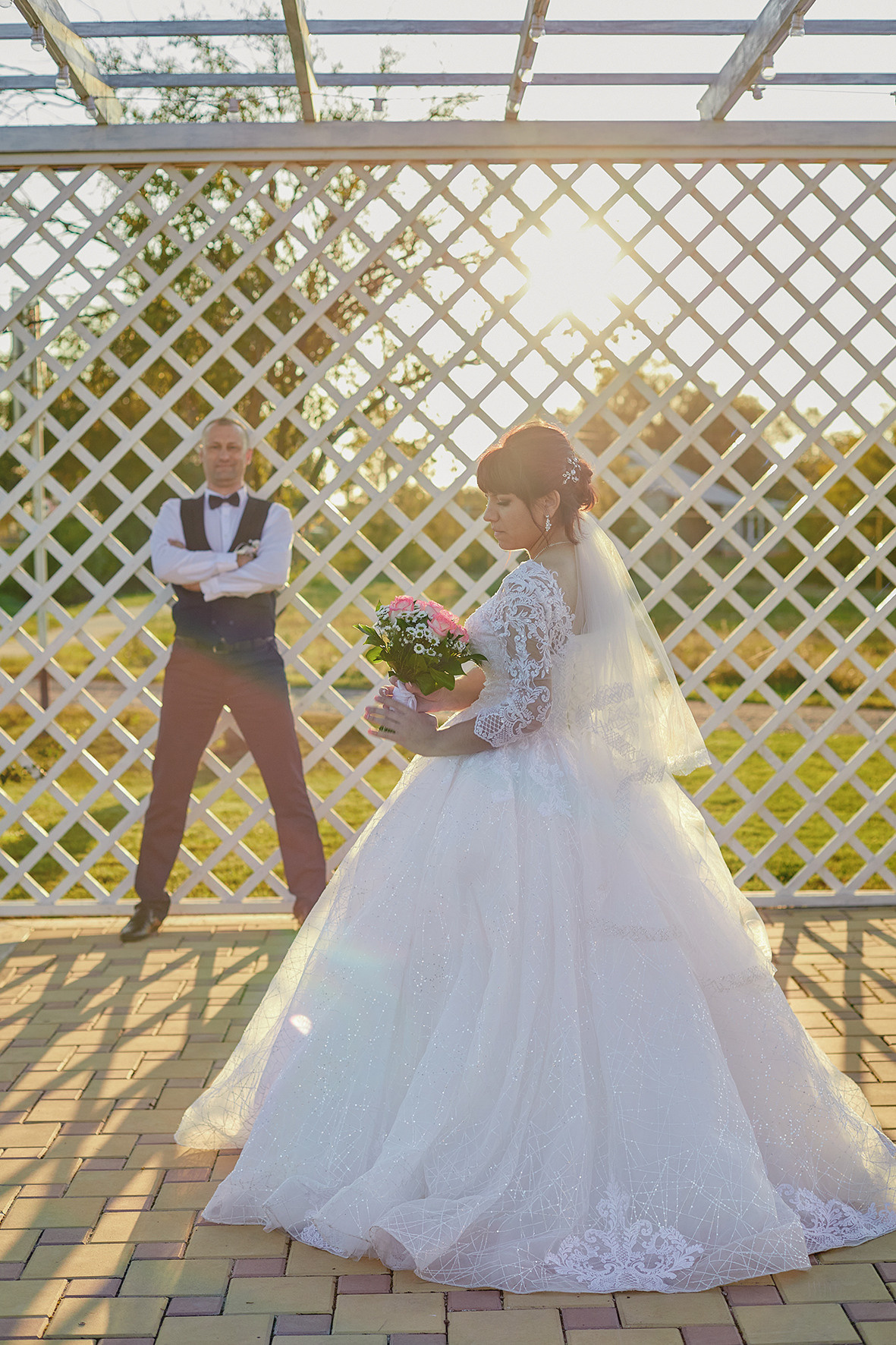 Невеста и жених стоят летней беседке на фоне заходящего солнца. Фотограф. Тимашевск. Кубань. Краснодарский край.