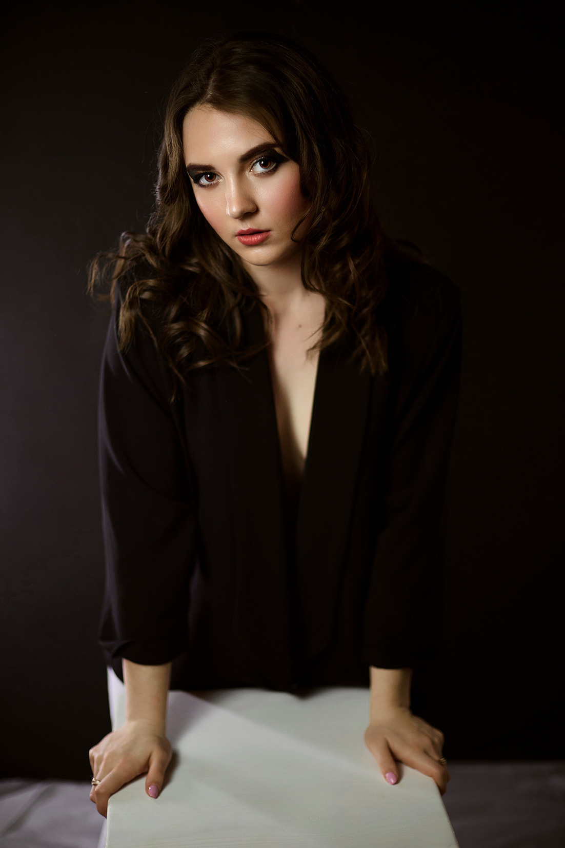 Студийный портрет девушки. Девушка с развивающимися волосами в черном пиджаке на голое тело на черном фоне. Фотограф. Тимашевск. Кубань. Краснодарский край.