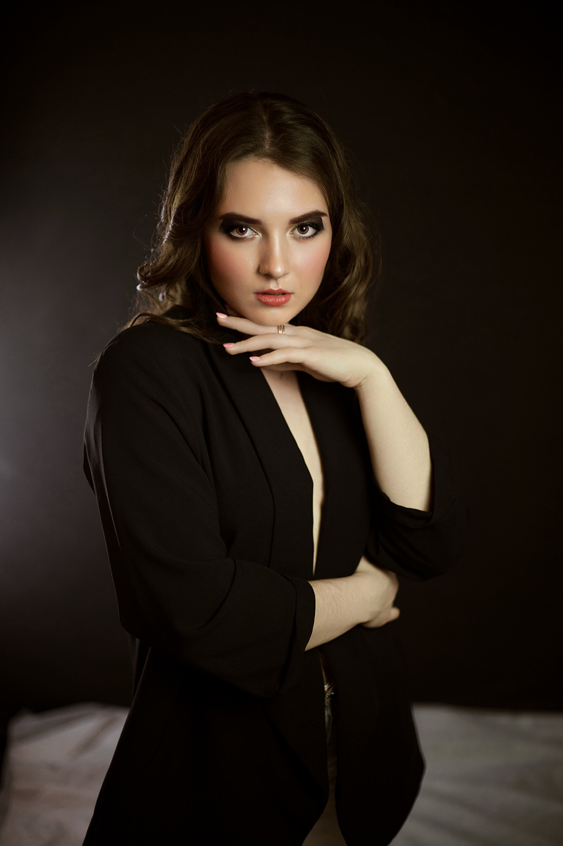 Студийный портрет девушки. Девушка с развивающимися волосами в черном пиджаке на голое тело на черном фоне. Фотограф. Тимашевск. Кубань. Краснодарский край.