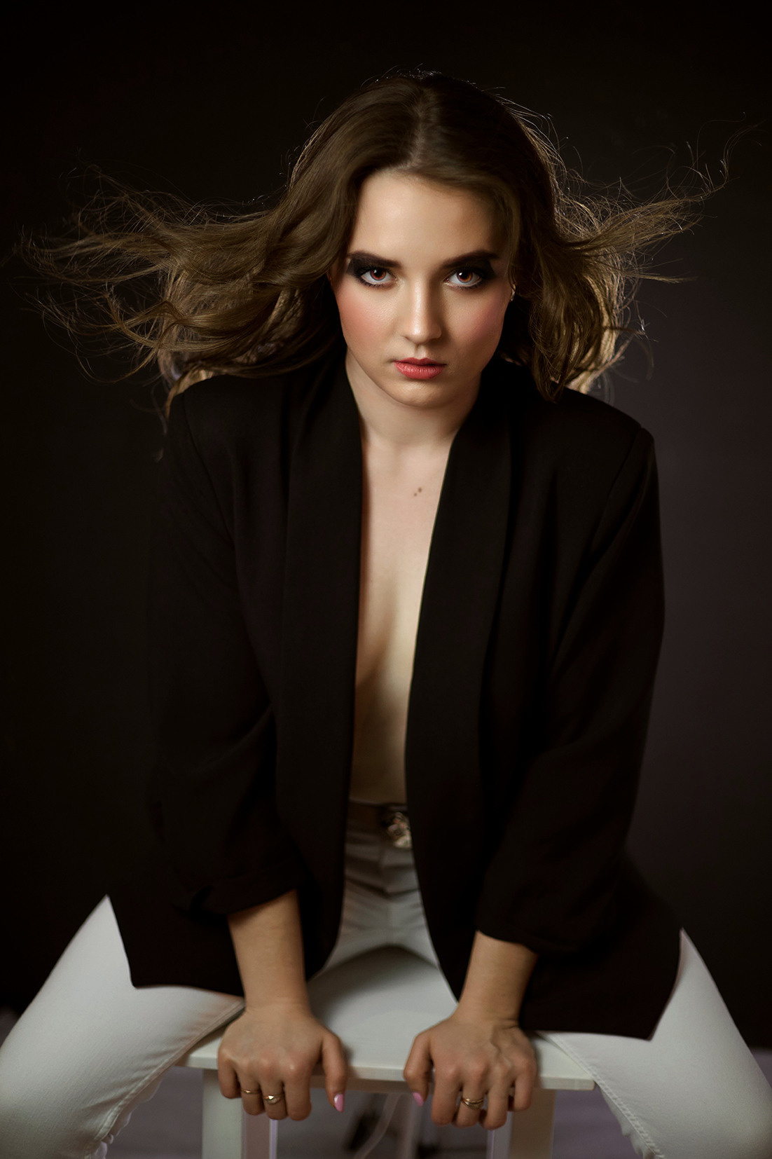 Студийный портрет девушки. Девушка с развивающимися волосами в черном пиджаке на голое тело на черном фоне. Фотограф. Тимашевск. Кубань. Краснодарский край.