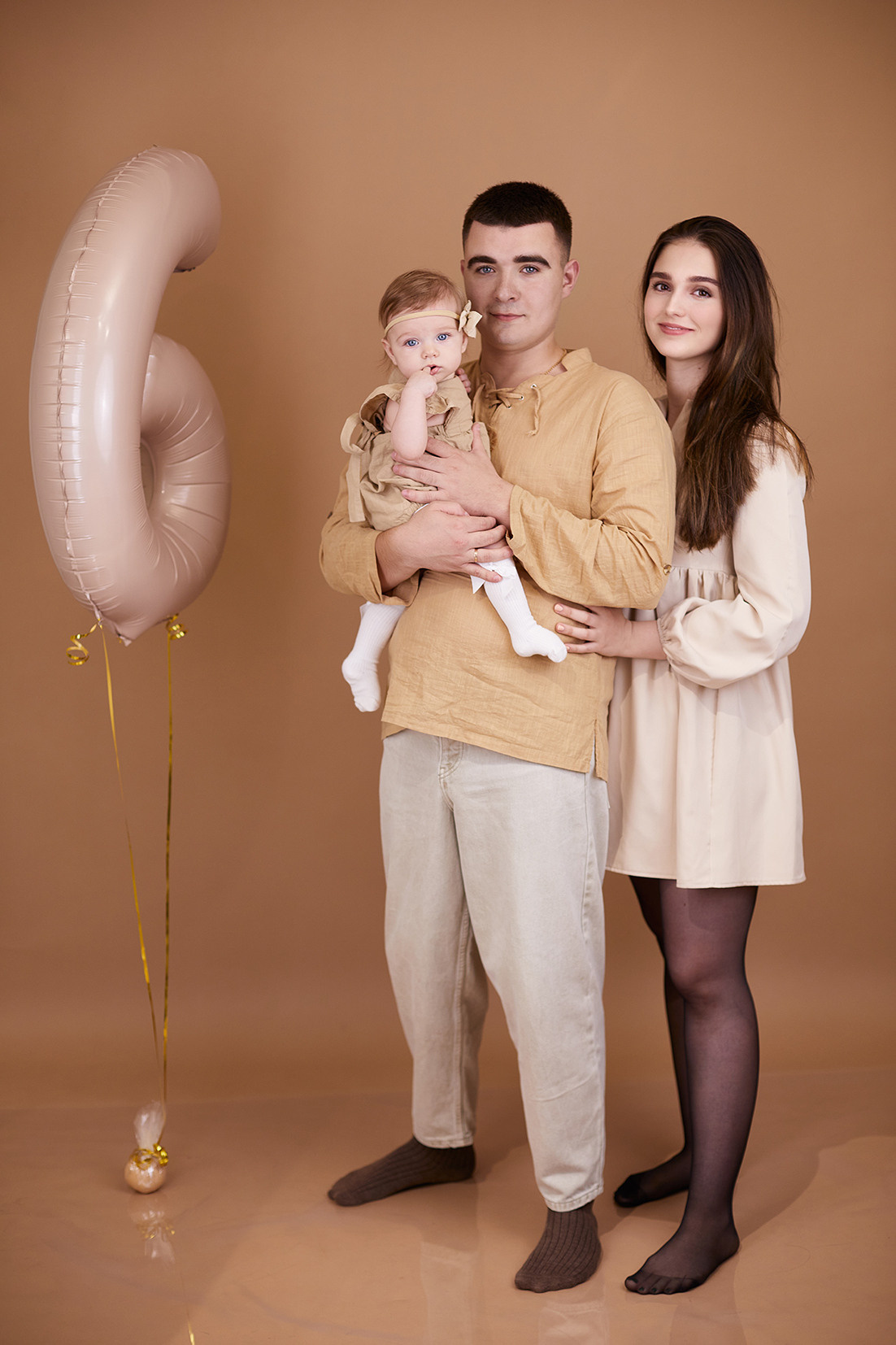 Студийный семейный портрет. Мама, папа и малышка на бежевом фоне. Фотограф. Тимашевск. Кубань. Краснодарский край.