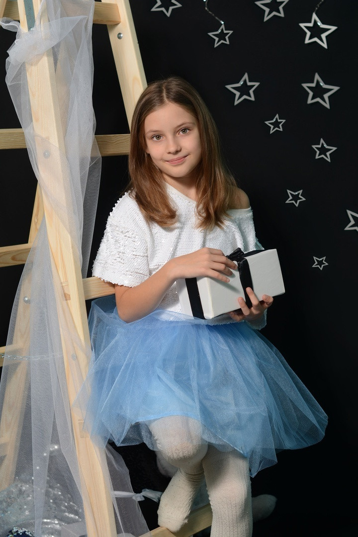 Девочка в воздушном платье с распущенными волосами.