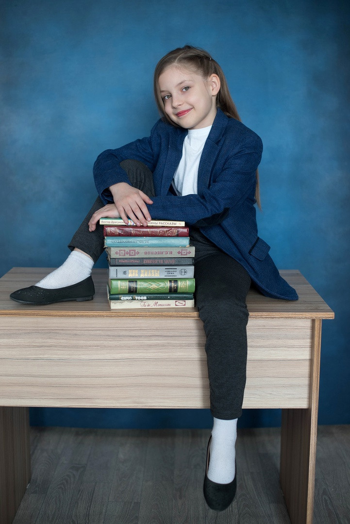 Школьные фотоальбомы стопочкой на парте.