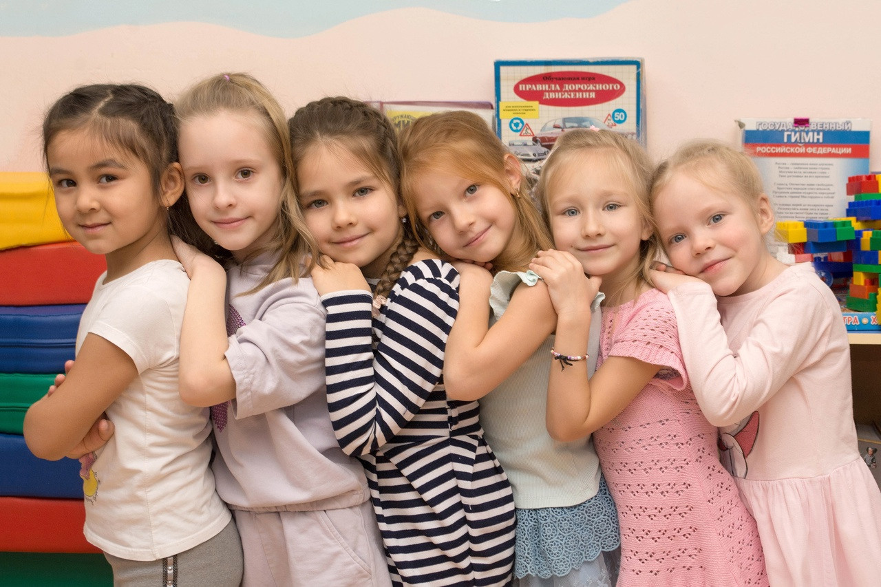 Дети стоят паровозиком облокотившись друг на друга.