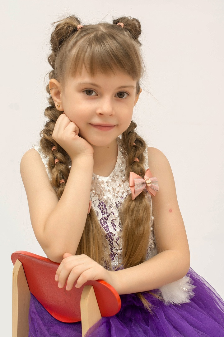 Девочка позирует фотографу на выпускной альбом.