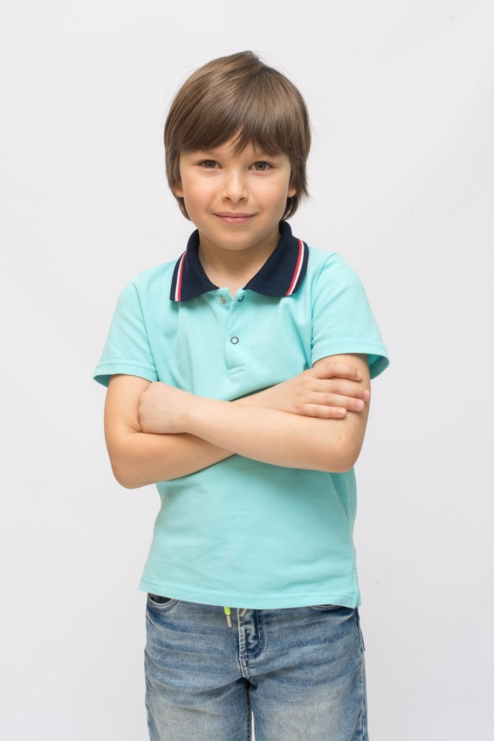 Фото мальчика в голубой футболке со скрещенными руками. 