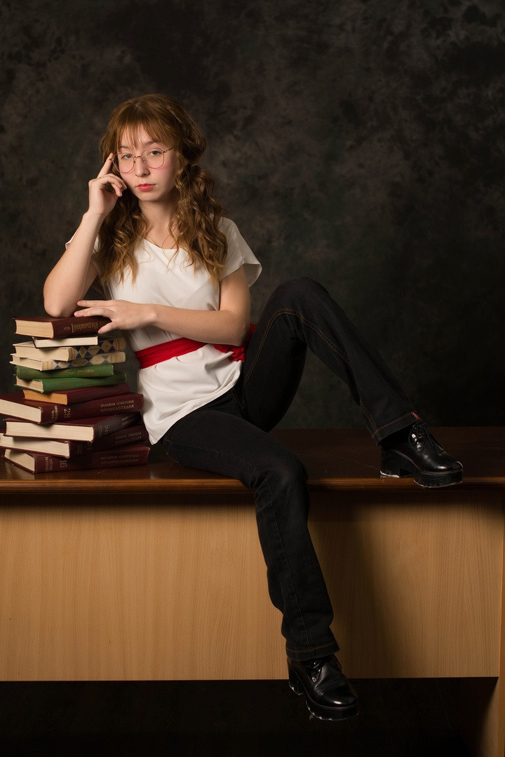 Фото за столом на парте на куче книг.