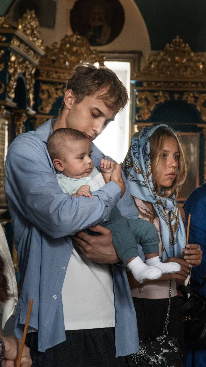 Атмосферная фотография Крещения: Крестный успокаивает младенца