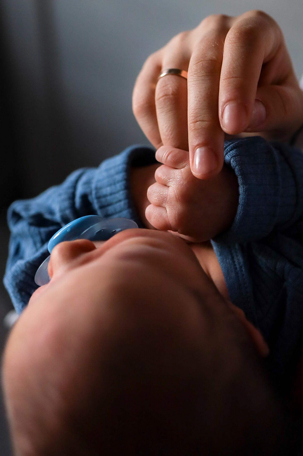 новорожденный малыш держит маму за палец