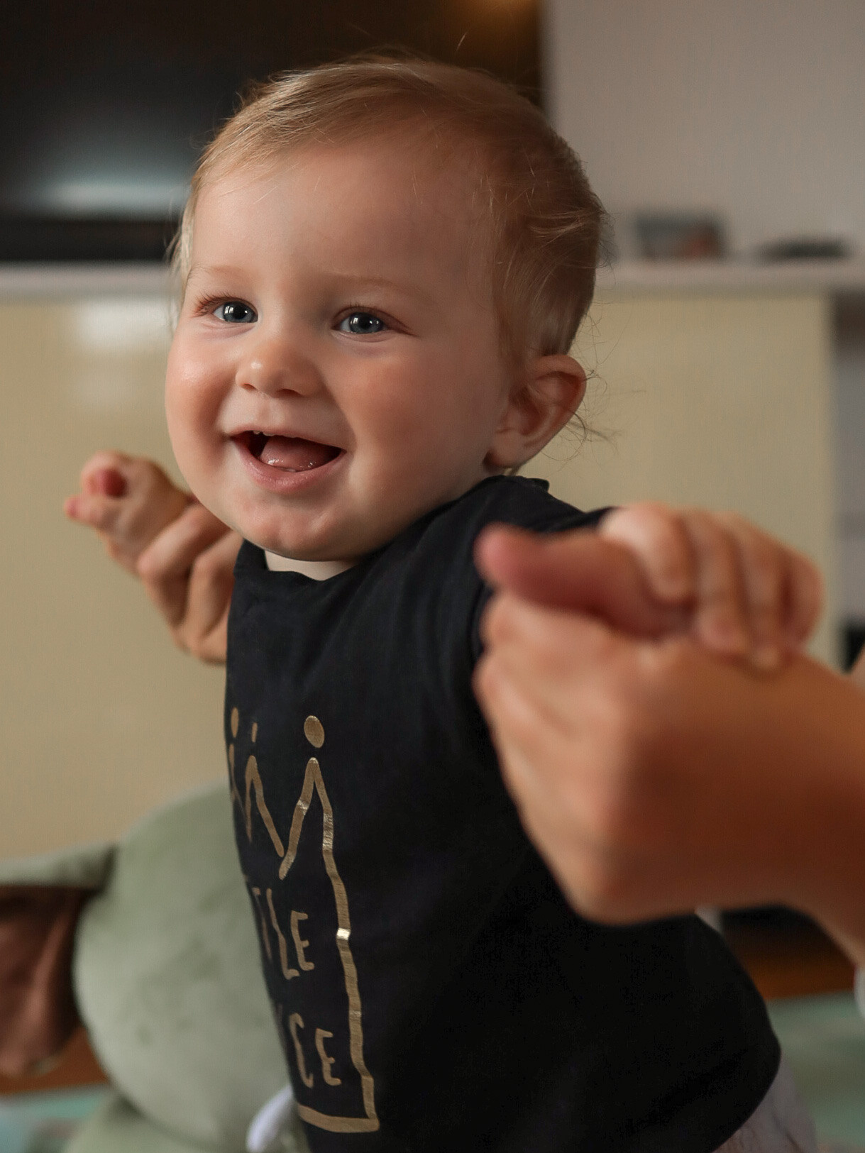 малыш учится стоять держась за мамины руки