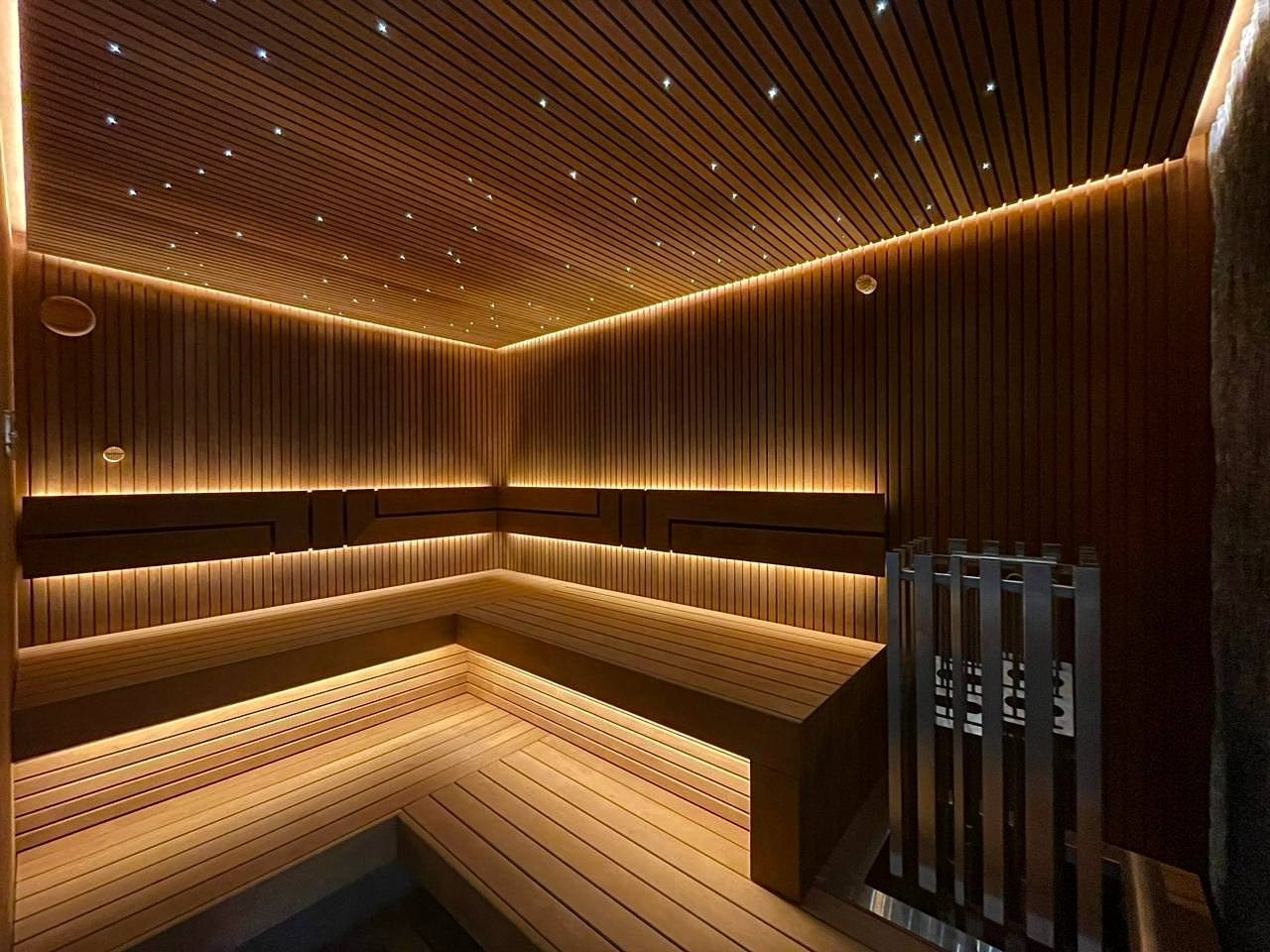 Сауна на Медном Озере из термоольхи «рейка», с тёплой подсветкой, звёздным небом и эффектным IKI Monolith на фоне итальянского камня. SaunaTopMasters