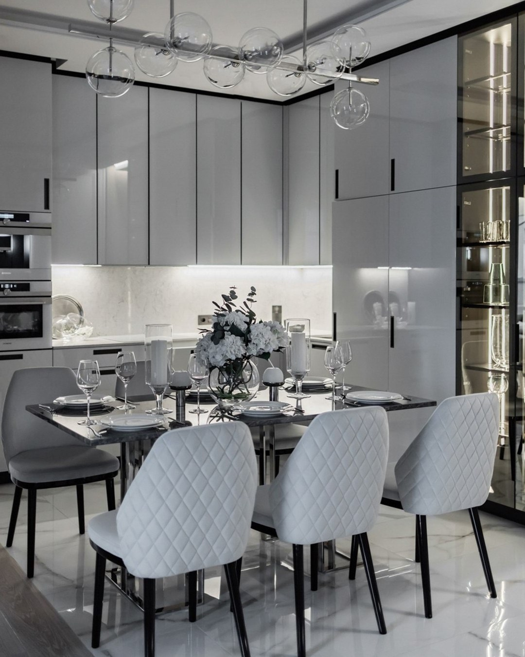 Современная кухня-столовая в белых тонах с мягкими стульями и мраморным полом | Проект Валерии Котович