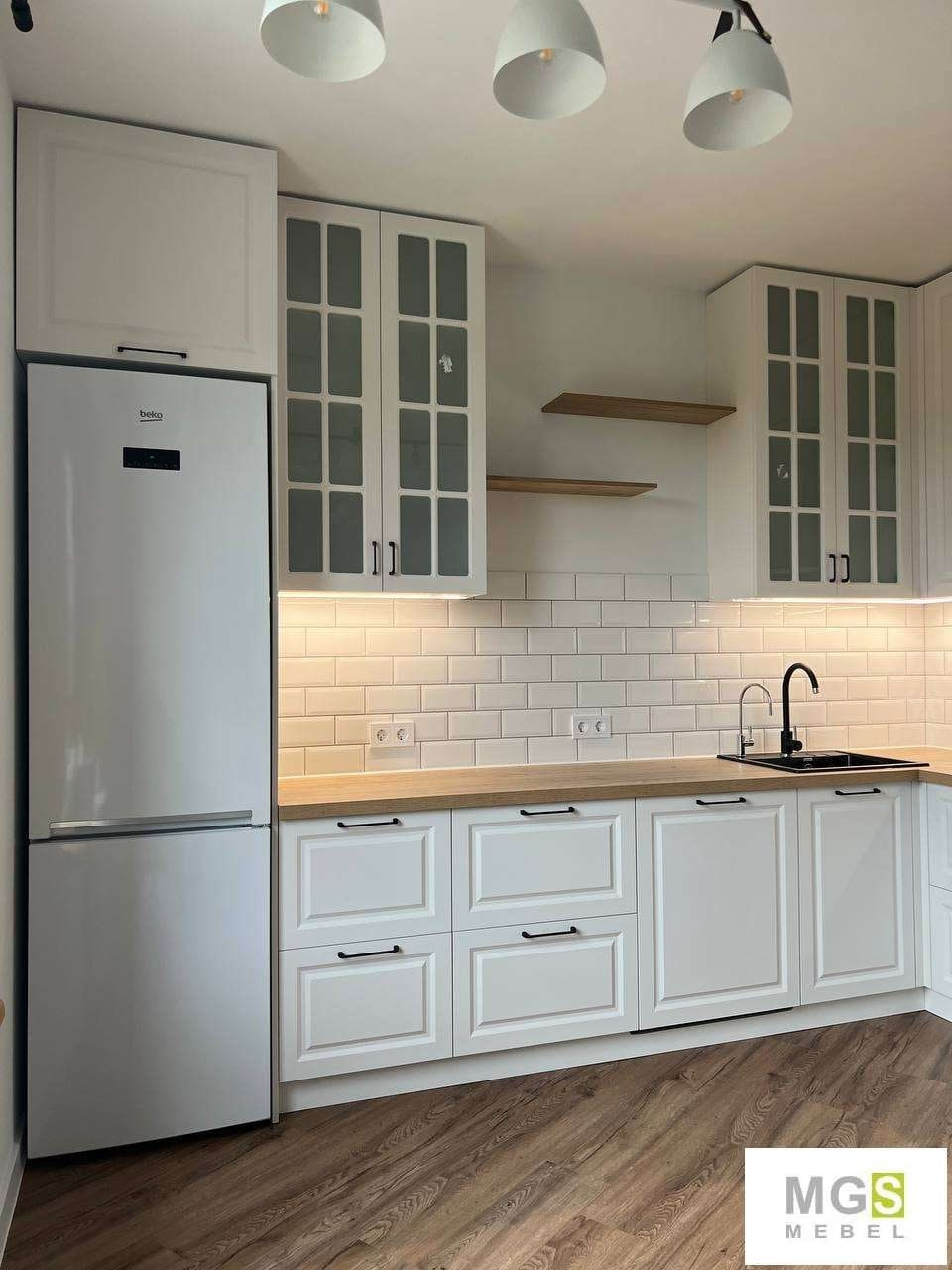 Красивая белая кухня с белыми фасадами, белым фартуком и рабочей поверхностью из дерева