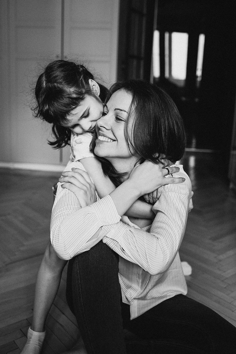 маленькая дочка обнимает свою маму  дома 