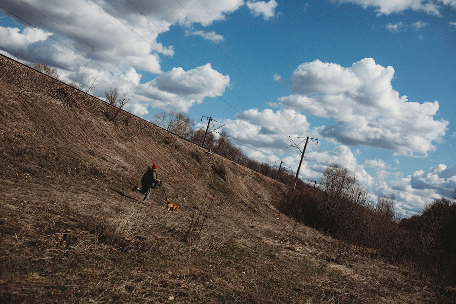 Девочка в джинсах гуляет со своей собакой на улице весной