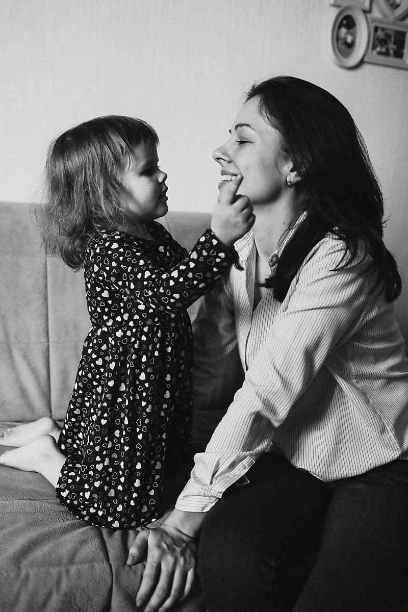 маленькая девочка играет со своей мамой в игры