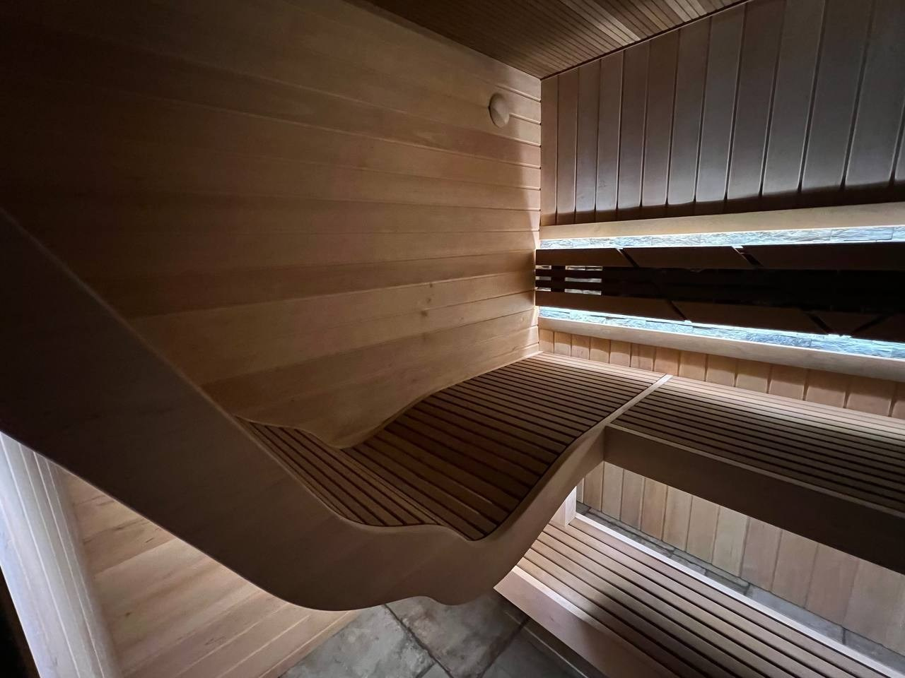Парная в Лисьем носу с анатомическим пологом и можжевеловым панно, а хромированная печь в свете оптоволокна создает неповторимую атмосферу. SaunaTopMasters