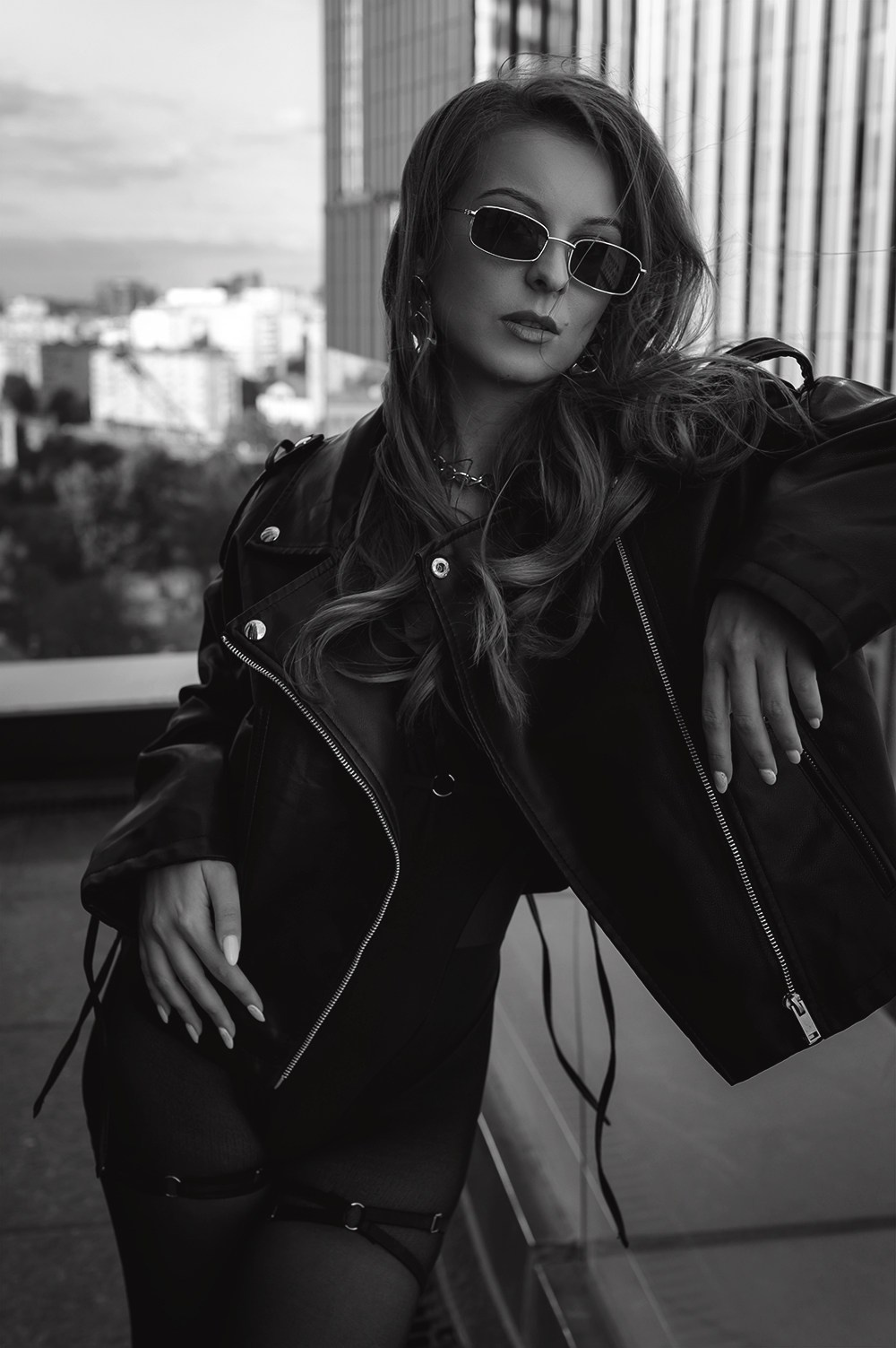 Чёрно-белое фото женщины в очках и кожаной куртке