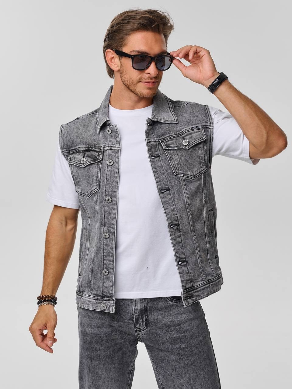 Фотосессия мужской одежды - мужчина в солнечных очках и джинсовой жилетке