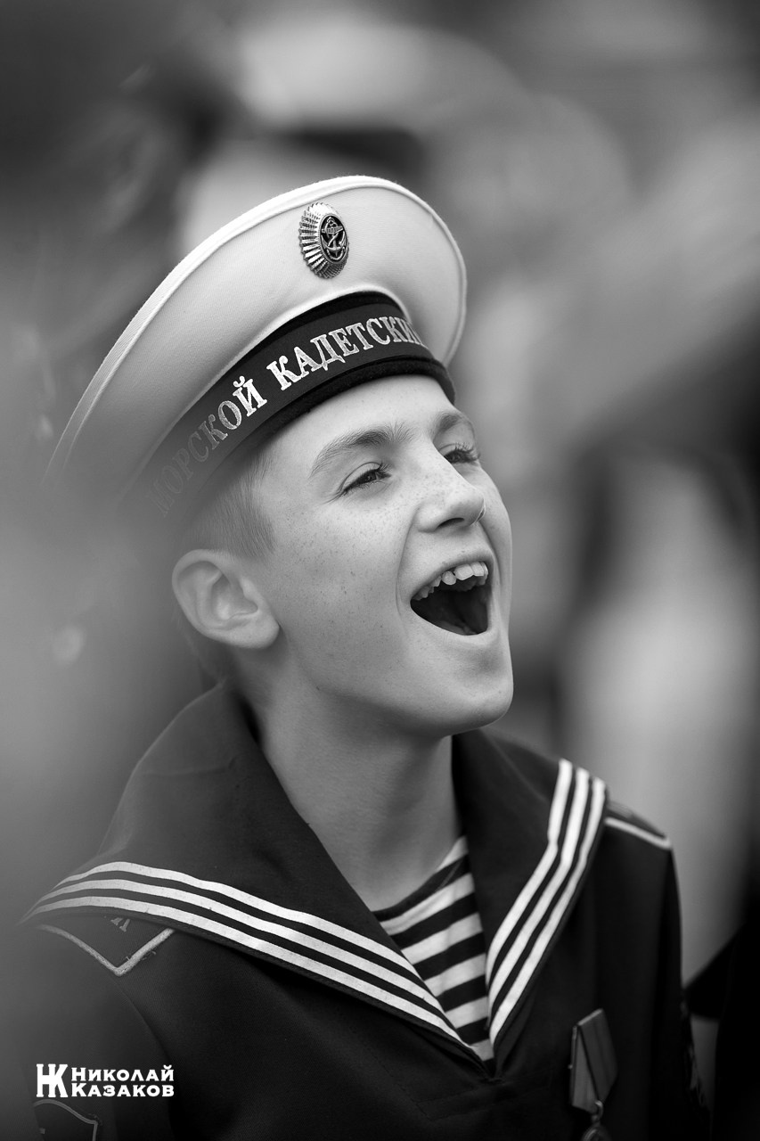 Черно-белый портрет смеющегося воспитанника Кронштадского морского кадетского военного корпуса на построении.