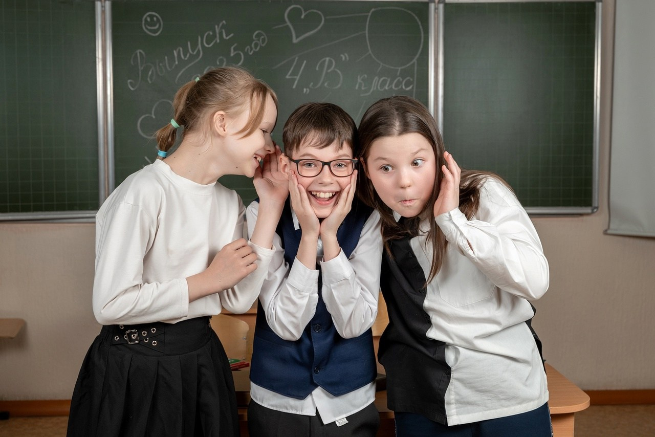 Смешливые школьники дурачатся на камеру в классе позируя фотографу.