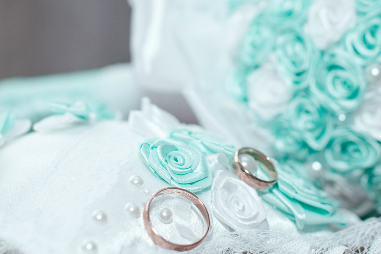 свадебные кольца на фоне букета невесты
