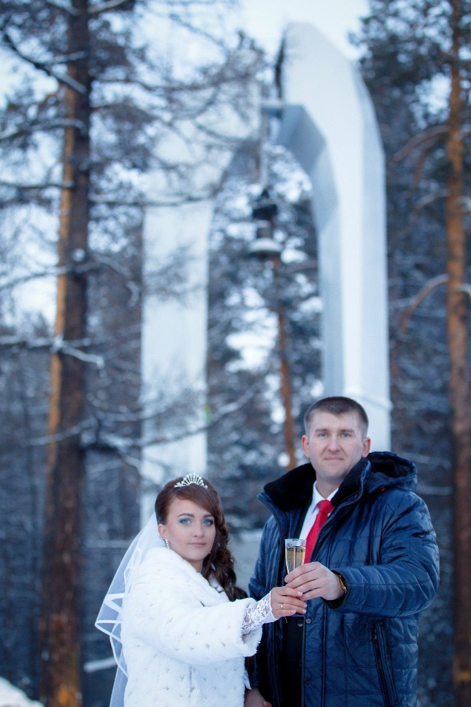 жених и невеста жержат бокал шампанского на фоне колокола