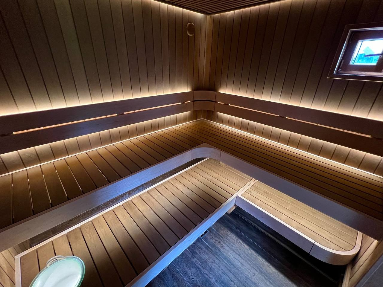 Парная в Колосе по индивидуальному проекту с реечным потолком, плавными линиями радиальных элементов и теплой закарнизной подсветкой. SaunaTopMasters