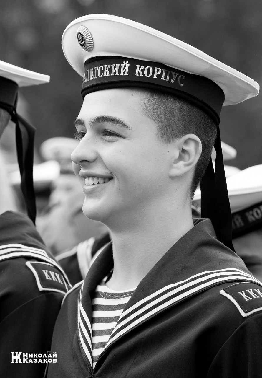 Черно-белый портрет смеющегося воспитанника Кронштадского морского кадетского военного корпуса на построении.