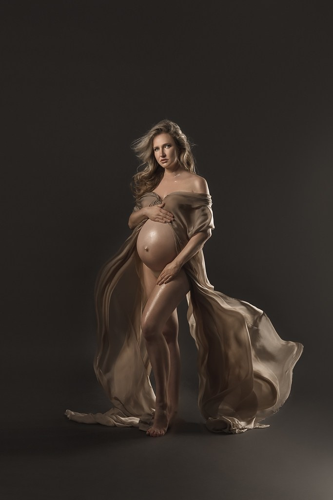 фотосессия беременной в фотостудии на темном фоне в красивом разлетающемся платье, фотография беременности, фотосессия беременных, портрет беременной