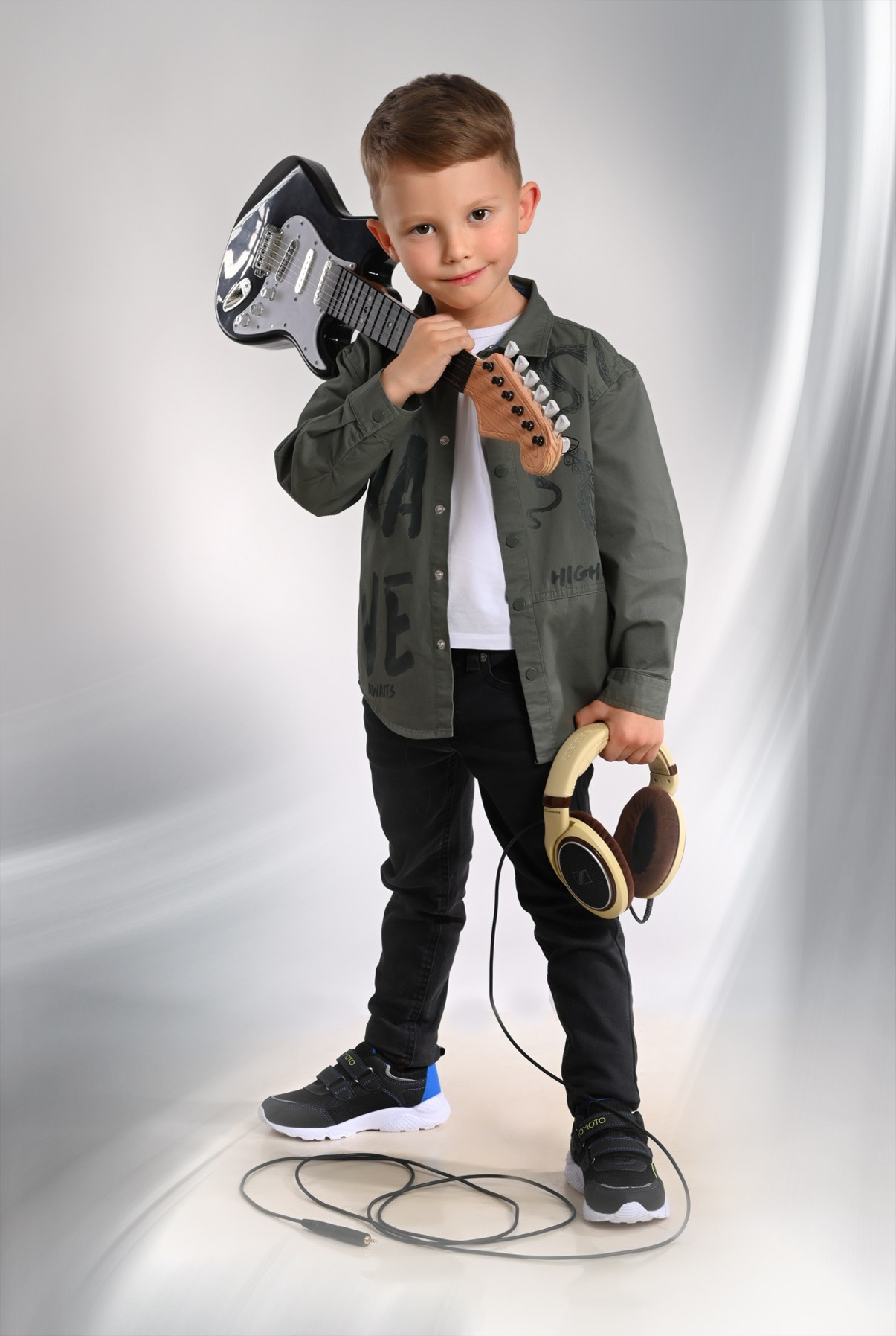 Мальчик выпускник детского сада в Вологде в костюме рок артиста с гитарой улыбается
