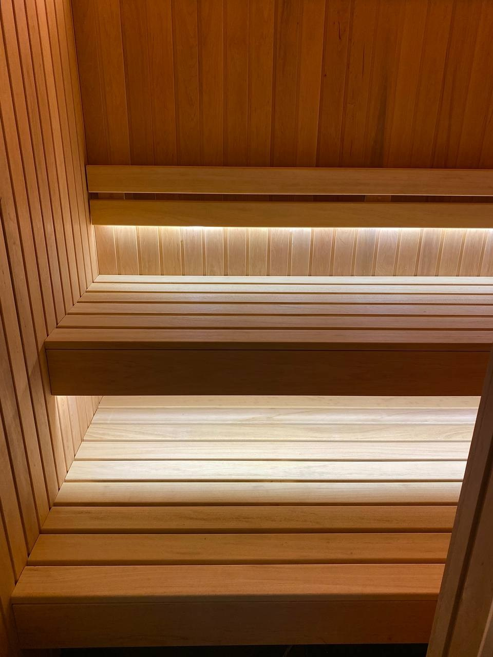 Компактная сауна в Охте: ольха, парящие полки, солевая линия 200 мм на базе электрокаменки Harvia Vega — максимум уюта в малом формате. SaunaTopMasters
