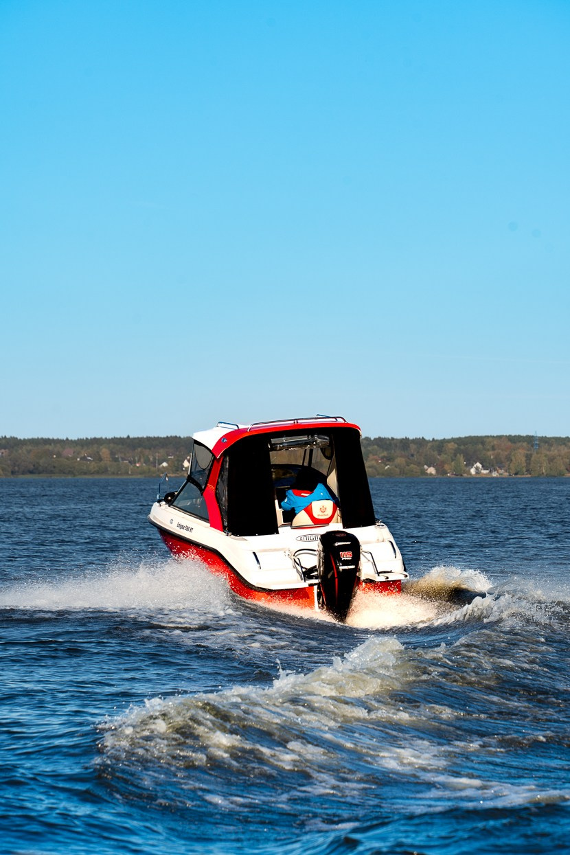 Красный катер Enigma делает разворот, брызги воды