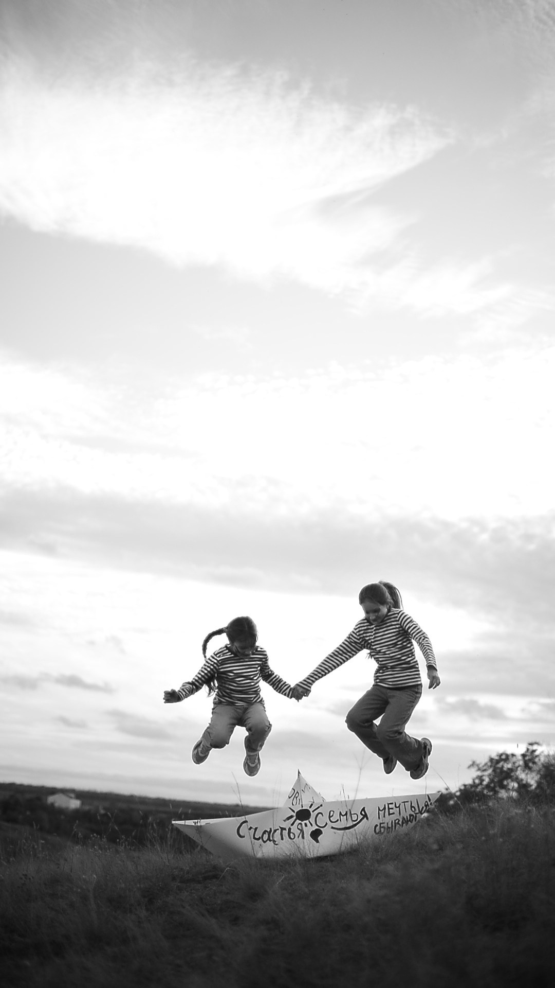 Дети прыгают через бумажный большой кораблик