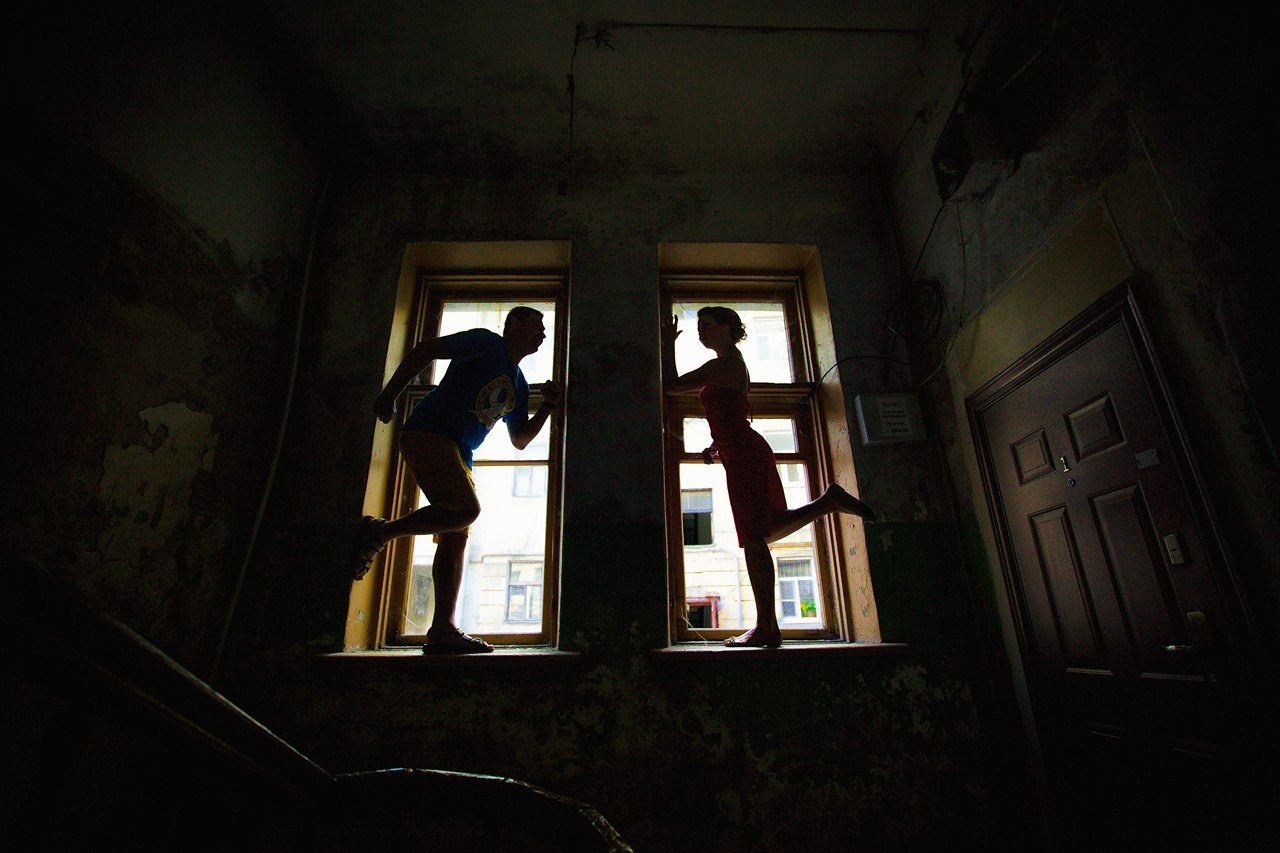 силуэты мужчины и женщины в больших окнах стариной комнаты