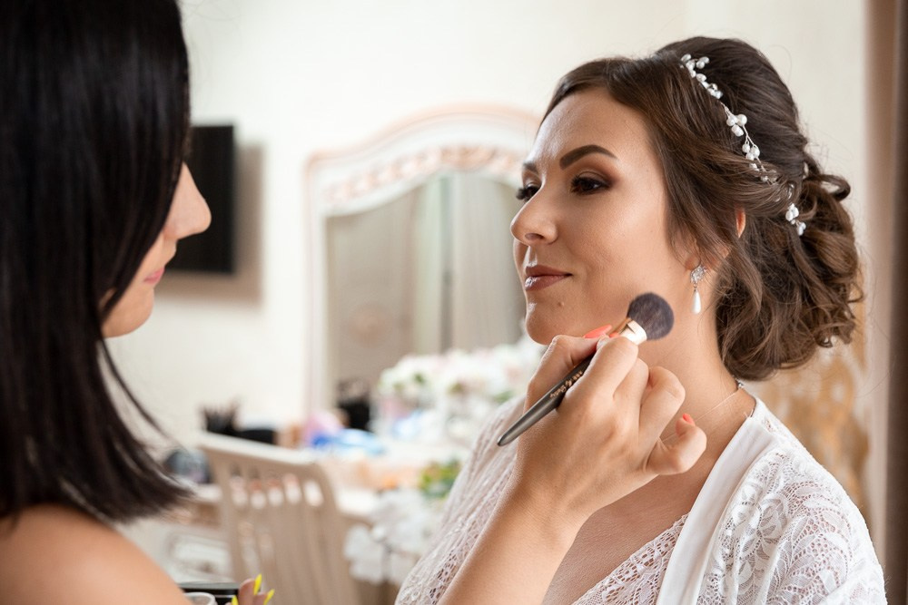 Визажист делает макияж невесте