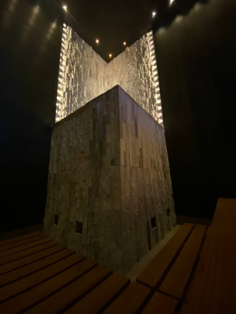 Чёрная «Богатырь-баня» в Боровске: четыре уровня полков, белый кварцит в противопожарном углу и кастомная газовая печь в центре внимания. SaunaTopMasters