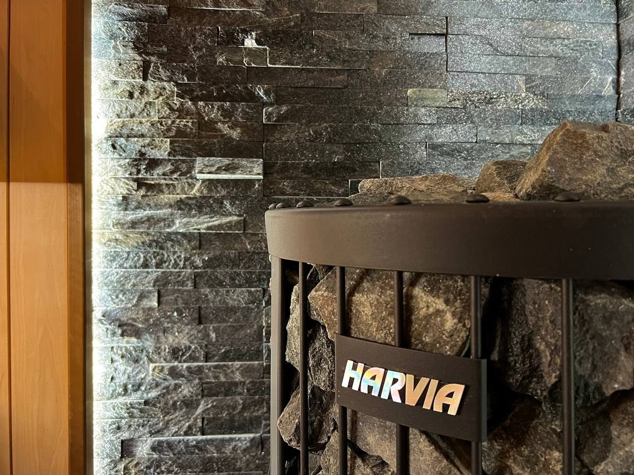 Просторная сауна в Сертолово из термоольхи с интеграцией можжевеловых линий и большого количества натурального камня. SaunaTopMasters