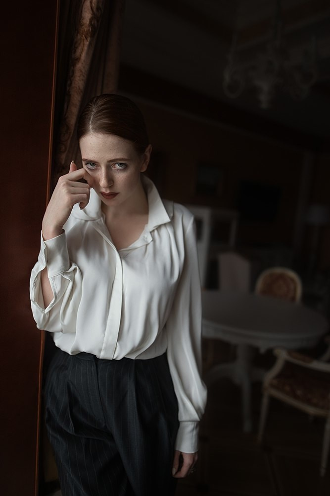 Студийный портрет девушки с веснушками и зелеными глазами