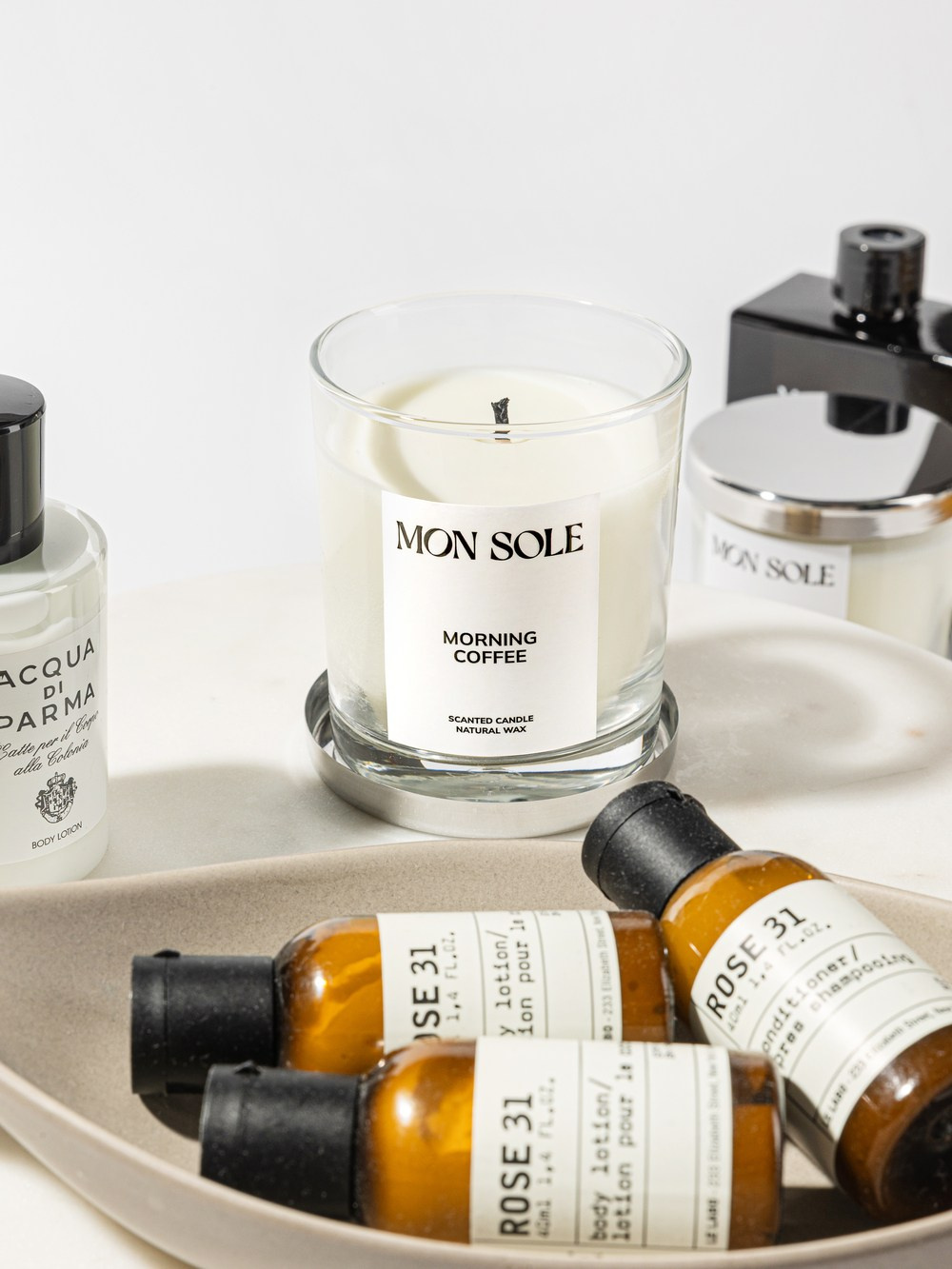 Свеча на металлической подставке рядом с косметикой