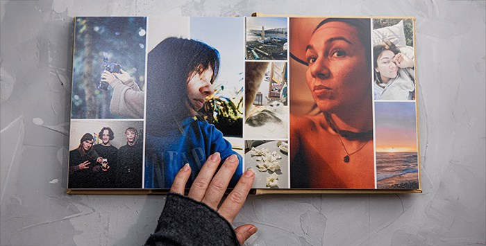 Прикосновение к воспоминаниям. Крупный план рук на страницах фотокниги с портретными снимками — матовая печать не оставляет следов.