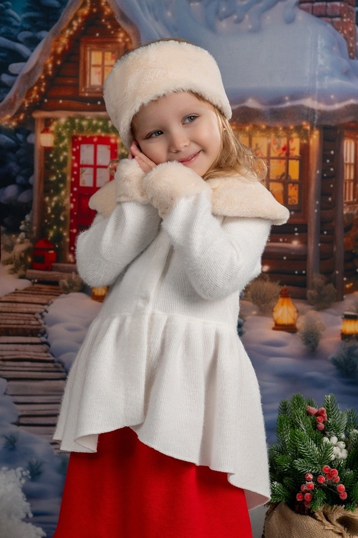 Девочка в белой шубке на новогоднем фото-проекте позирует фотографу.